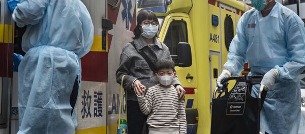 Женщина с ребенок в защитных масках рядом с автомобилем скорой помощи на одной из улиц в Гонконге. - Sputnik Абхазия