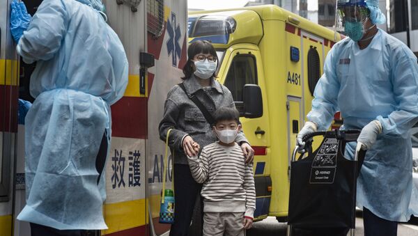 Женщина с ребенок в защитных масках рядом с автомобилем скорой помощи на одной из улиц в Гонконге. - Sputnik Абхазия