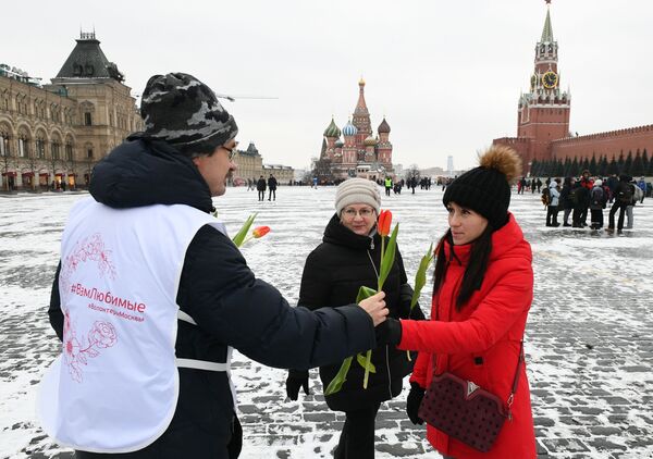 Волонтер дарит цветы и поздравляет женщин с Международным женским днем на Красной площади - Sputnik Абхазия