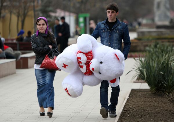 Мужчина несет подаренного девушке плюшевого медведя накануне праздника 8 марта в Грозном - Sputnik Абхазия