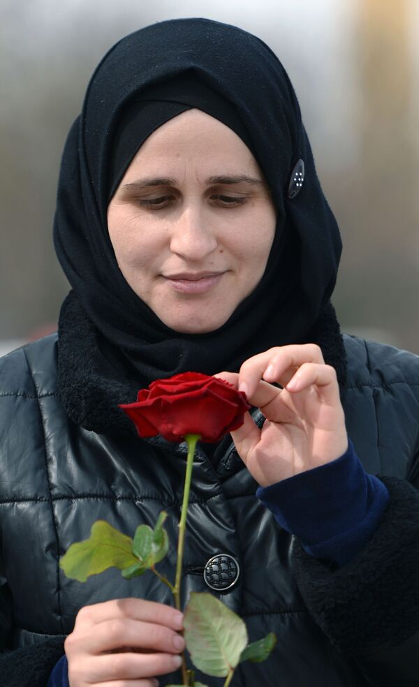 Женщина с розой 8 марта на одной из улиц Грозного - Sputnik Абхазия