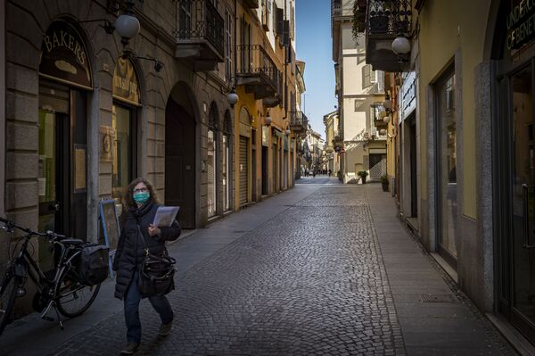 Женщина в маске но одной из улиц Новары, Италия - Sputnik Абхазия