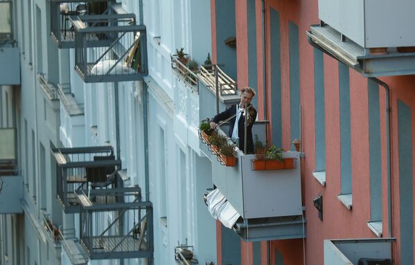 Мужчина играет на скрипке во время карантина на балконе в Берлине - Sputnik Абхазия