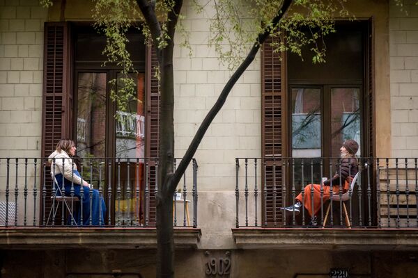 Женщины общаются между собой со своих балконов в Барселоне. Многие жители города не выходят из своих домов из-за коронавируса.  - Sputnik Абхазия