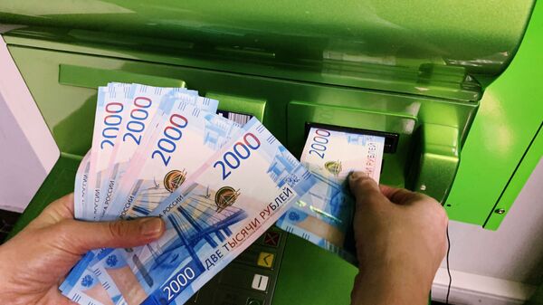 Клиент вносит наличные деньги в банкомат - Sputnik Абхазия
