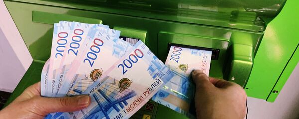 Клиент вносит наличные деньги в банкомат Клиент вносит наличные деньги в банкомат - Sputnik Абхазия