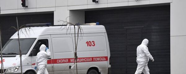 Сотрудники скорой помощи в защитных костюмах на территории больничного комплекса в Коммунарке Сотрудники скорой помощи в защитных костюмах на территории больничного комплекса в Коммунарке - Sputnik Абхазия