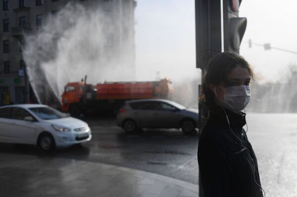 Девушка в медицинской маске стоит на переходе на Тверской улице - Sputnik Абхазия