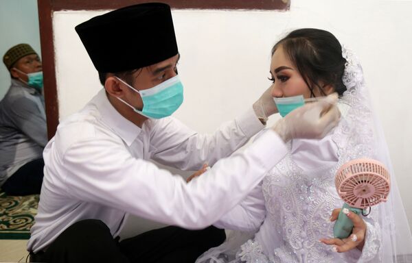 Жених и невеста в масках в Джакарте  - Sputnik Абхазия
