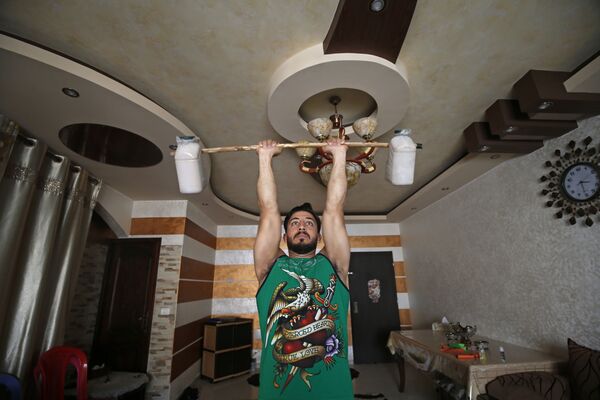 Палестинский тренер по фитнесу и бодибилдингу Ахмед Сави во время тренировки у себя дома - Sputnik Абхазия