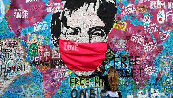  Женщина в маске у легендарной стены Джона Леннона в Праге - Sputnik Абхазия