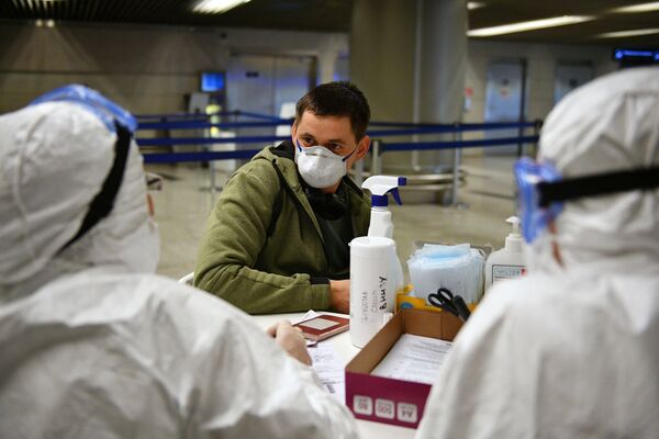 Медицинские работники во время проверки состояния пассажира в аэропорту Внуково - Sputnik Абхазия