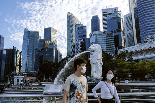 Пара в масках у статуи Мерлиона в Сингапуре - Sputnik Абхазия