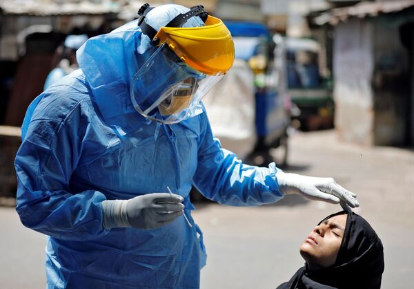 Доктор в защитном костюме тестирует девушку на коронавирус в Ахмедабаде, Индия - Sputnik Абхазия