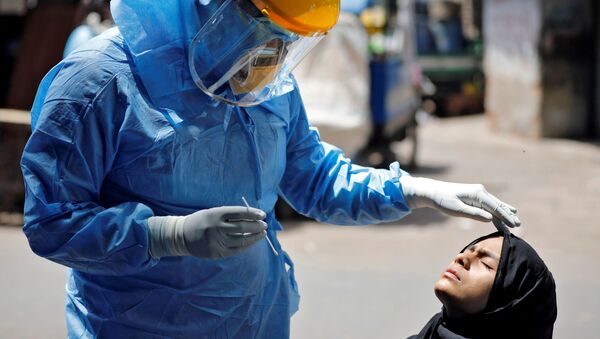 Доктор в защитном костюме тестирует девушку на коронавирус в Ахмедабаде, Индия - Sputnik Аҧсны