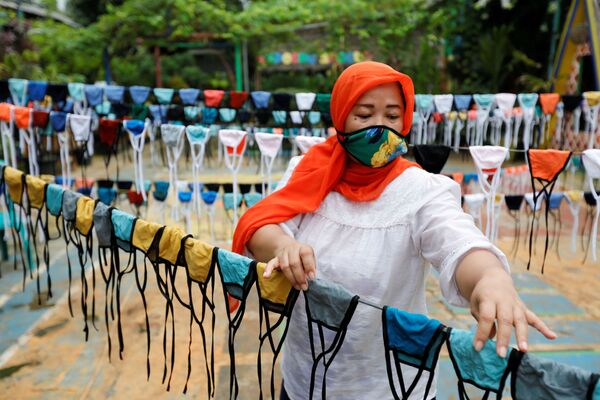 Женщина в защитной маске во время изготовления масок в Тангеранге на окраине Джакарты, Индонезия - Sputnik Абхазия