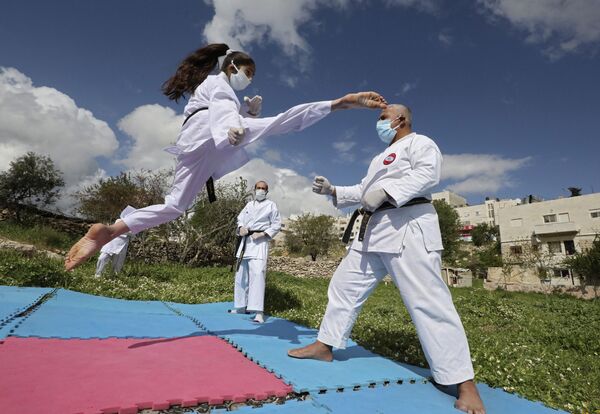 Палестинская чемпионка по карате во время тренировки со своим отцом дома в Хевроне  - Sputnik Абхазия