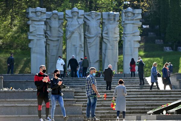 В Литве, несмотря на карантин, жители столицы отправились к мемориалам павших советских воинов, чтобы возложить цветы в честь их подвига  - Sputnik Абхазия