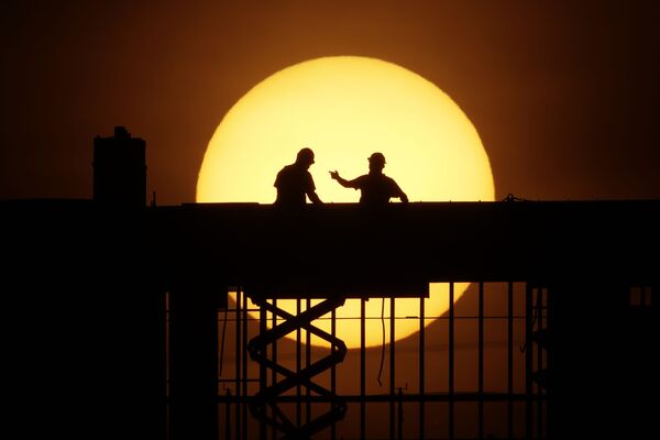 Рабочие на фоне восходящего солнца на стройке в Канзас-сити, штат Миссури, США - Sputnik Абхазия