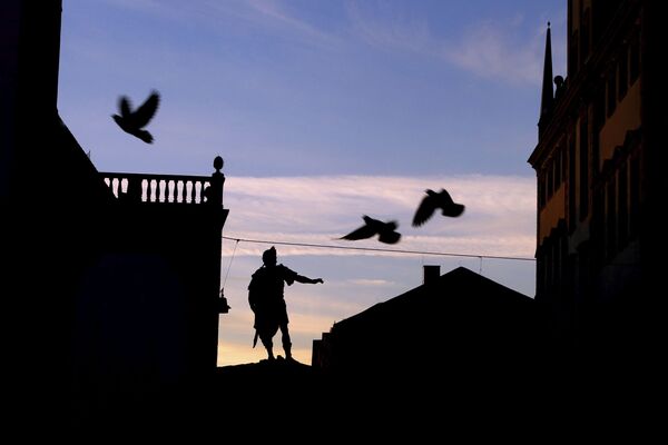 Голуби летают над ратушной площадью незадолго до восхода солнца в Аугсбурге, Германия - Sputnik Абхазия