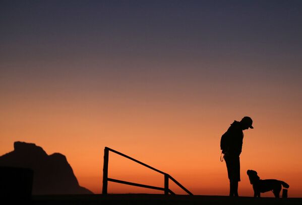 Мужчина во время прогулки с собакой на рассвете в Рио-де-Жанейро, Бразилия - Sputnik Абхазия