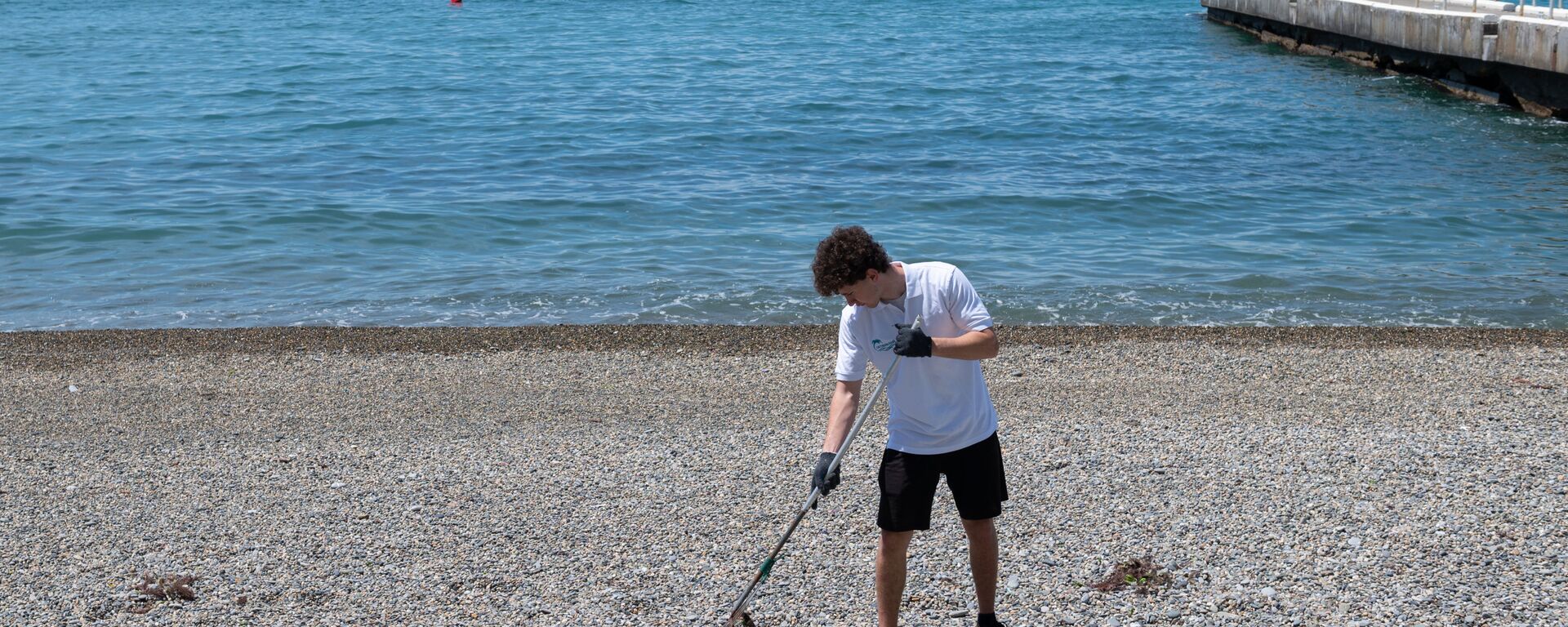 Сотрудник санатория Октябрьский в Сочи чистит пляж от мусора - Sputnik Абхазия, 1920, 01.08.2025