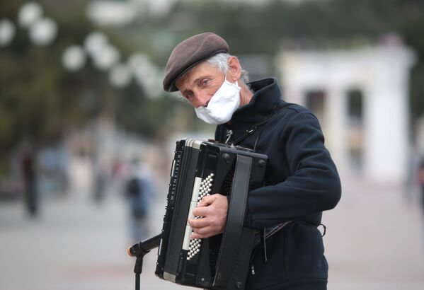  Уличный музыкант на набережной Алушты после отмены режима самоизоляции в Крыму - Sputnik Абхазия