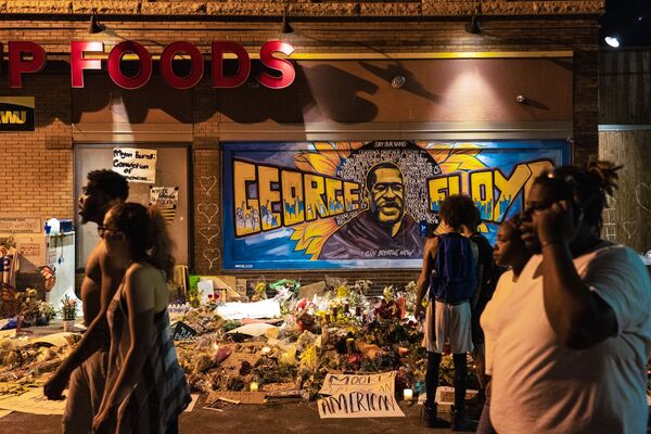 Цветы и свечи на фоне граффити с портретом афроамериканца Джорджа Флойда на месте его убийства  в Миннеаполисе штат Миннесота - Sputnik Абхазия