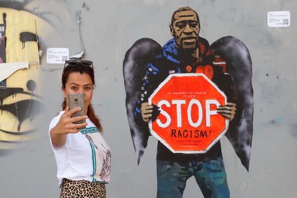 Селфи на фоне изображения Джорджа Флойжа, сделанного художником Сальваторе Бенинтендэ, известного как TVBOY, в Барселоне - Sputnik Абхазия
