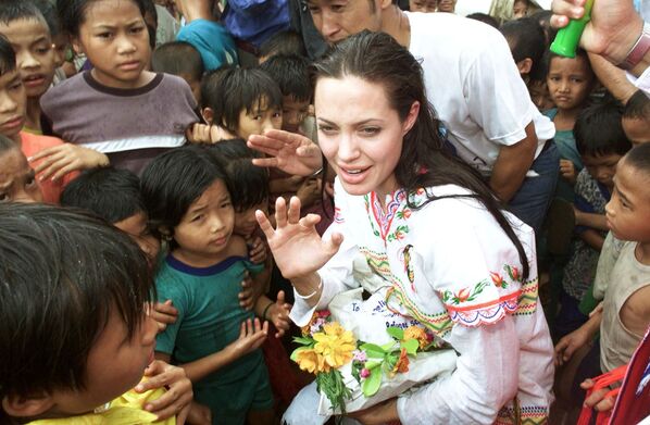 American actress Angelina Jolie (C) receives gifts from the children at the Tham Hin refugee camp on the Thai-Burma border May 19, 2002. Jolie visited the camp on Sunday, some 180 kilometres (111 miles) west of Bangkok, as part of her role as goodwill ambassador for the United Nations High Commissioner for Refugees.  AFP PHOTO/Sukree SUKPLANG/POOL (Photo by SUKREE SUKPLANG / POOL / AFP) - Sputnik Абхазия