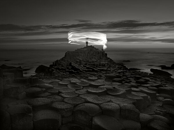 Снимок Giant's Causeway and figure, Northern Ireland фотографа  Ugo Ricciardi , занявший третье место в категории  Movement/Fine Art конкурса IPA OneShot Movement 2020 - Sputnik Абхазия