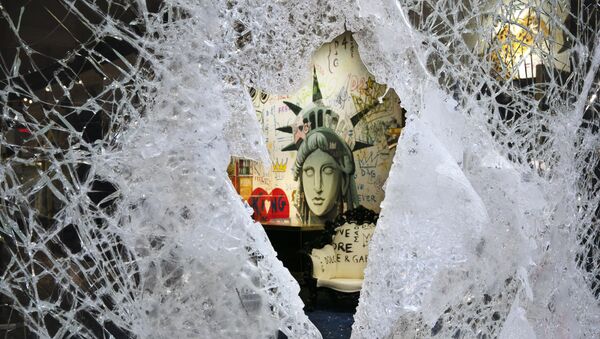 Рисунок разбитой статуи Свободы виден через разбитую витрину Dolce and Gabbana в понедельник, 1 июня 2020 года, в районе Сохо в Нью-Йорке. Протестующие ворвались в магазин в воскресенье вечером в ответ на смерть Джорджа Флойда, находясь под стражей в полиции 25 мая в Миннеаполисе - Sputnik Абхазия