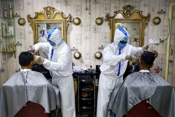 Барберы в защитных костюмах в одном из парикмахерских салонов Дакки, Бангладеш - Sputnik Абхазия