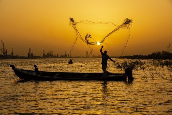  Рыбак закидывает сеть на закате на реке Шатт-эль-Араб в иракском городе Басра - Sputnik Абхазия
