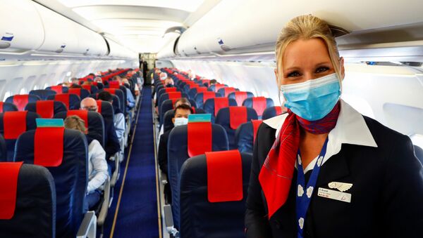 Стюардесса в медицинской маске в салоне самолета в международном аэропорту Брюсселя - Sputnik Абхазия