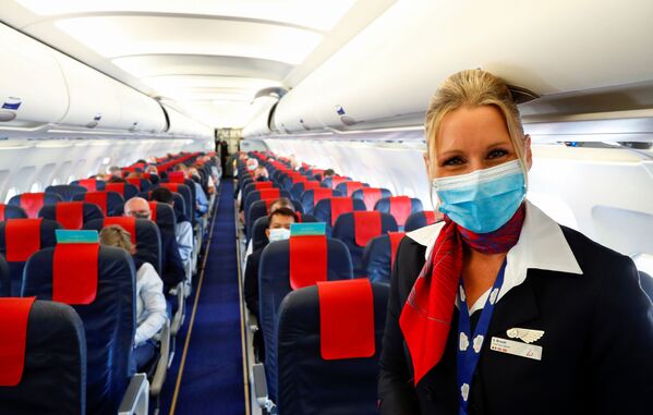 Стюардесса в медицинской маске в салоне самолета в международном аэропорту Брюсселя - Sputnik Абхазия