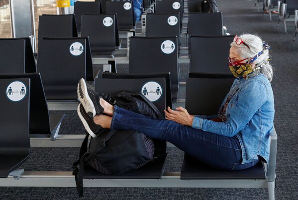 Пассажирка в защитной маске в терминале  международного аэропорта Брюсселя - Sputnik Абхазия