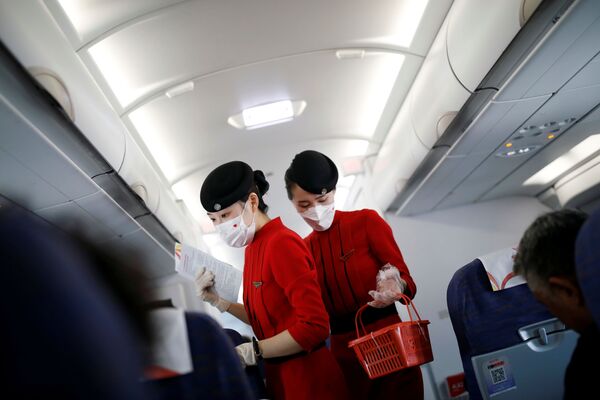 Бортпроводницы в масках и перчатках на борту самолета авиакомпании Сычуань, Китай - Sputnik Абхазия
