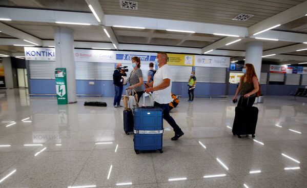 Туристы из Германии в медицинских масках в аэропорту Пальма-де-Майорка в Испании - Sputnik Абхазия