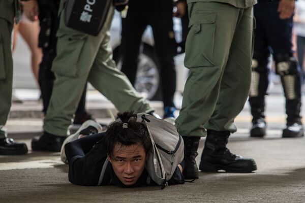 Задержанный полицией участник акции протеста против нового закона о национальной безопасности в Гонконге - Sputnik Абхазия